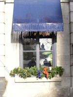 Icicles on a window awning with a reflection of Alan