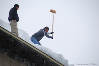Knocking ice of the roof opposite the Alpina hotel