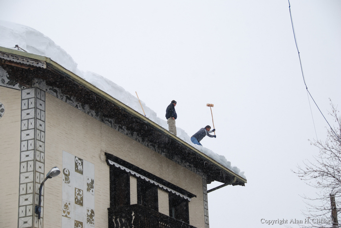 Knocking ice of the roof opposite the Alpina hotel