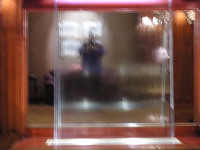 Alan reflected in the mirror behind the water sculpture in the Manoir Victoria hotel